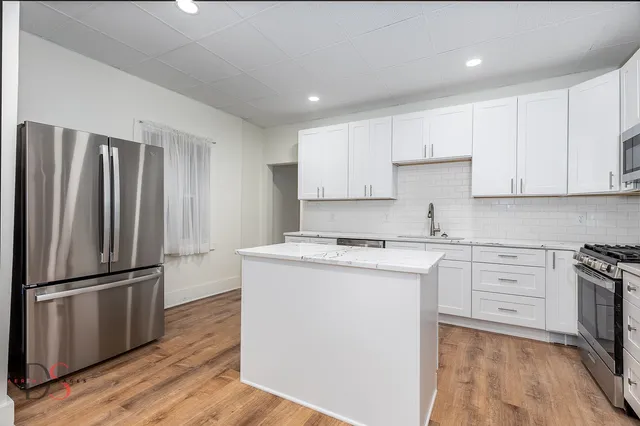 a kitchen with a refrigerator sink and cabinets