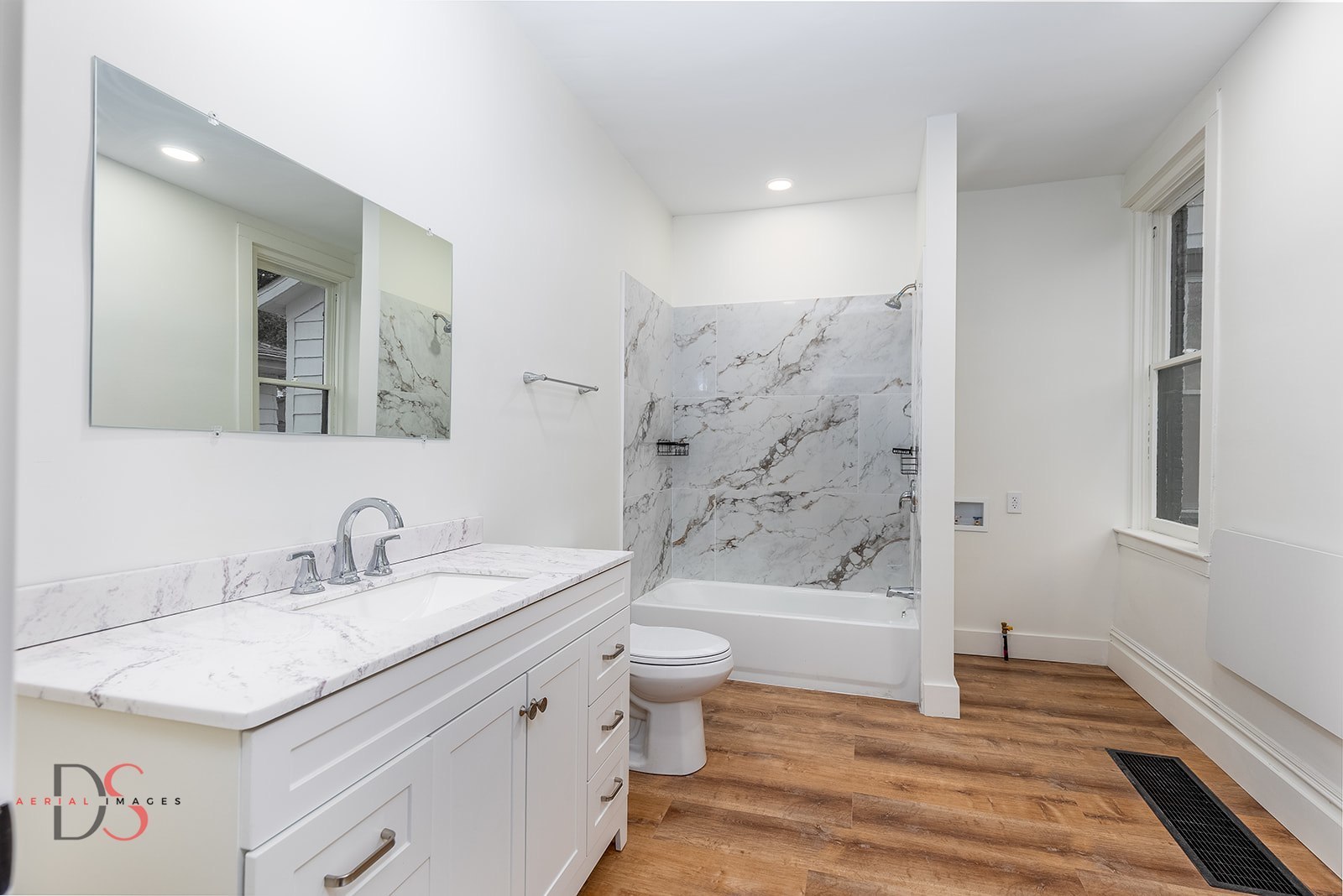 1009 Paul Street Ottawa, IL 61350 - Photo 6 of 18 a bathroom with a granite countertop sink a toilet a mirror a vanity and bathtub
