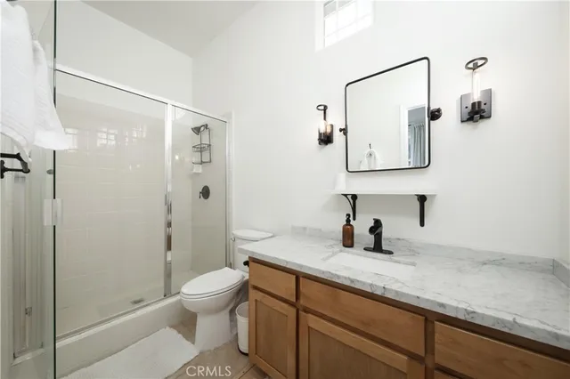 a bathroom with a granite countertop sink toilet and shower