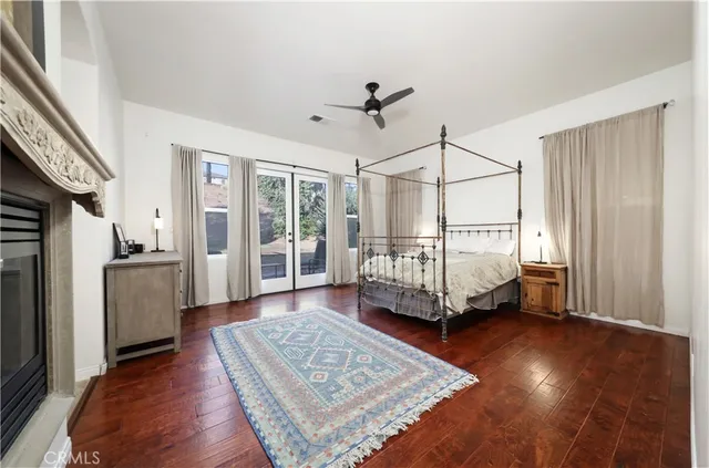 a spacious bedroom with a bed and wooden floor
