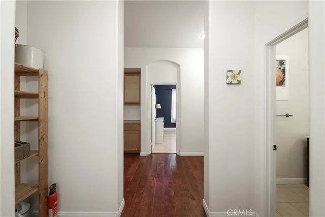 a view of a hallway with wooden floor and a bathroom