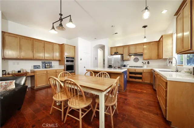 a view of a dining room with furniture a kitchen and chandelier