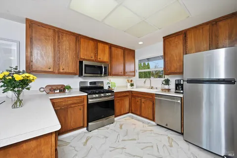 a kitchen with granite countertop stainless steel appliances and wooden cabinets