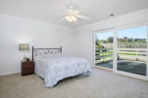 a spacious bedroom with a bed and a view of chandelier