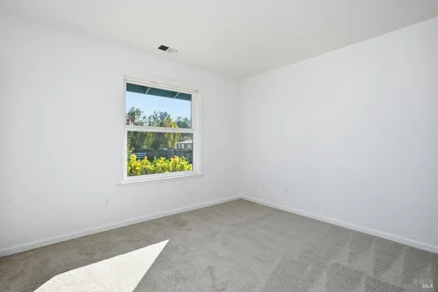 an empty room with window and mirror