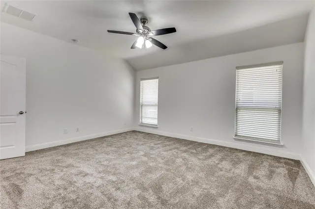 an empty room with windows and fan