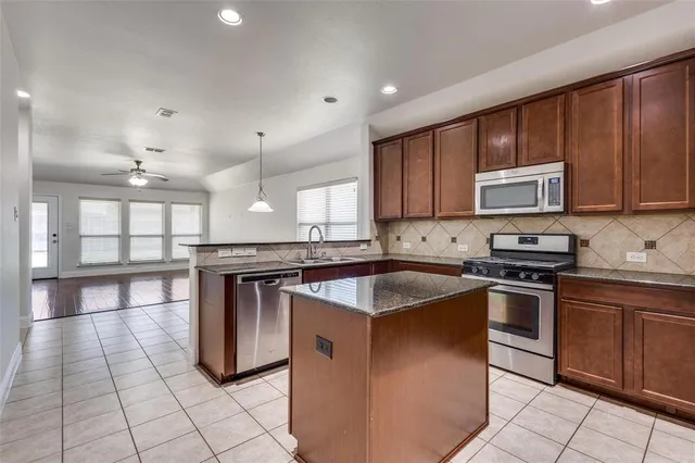 a kitchen with stainless steel appliances granite countertop a sink stove and cabinets