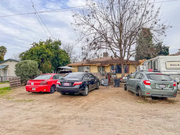 a front view of a house with cars parked