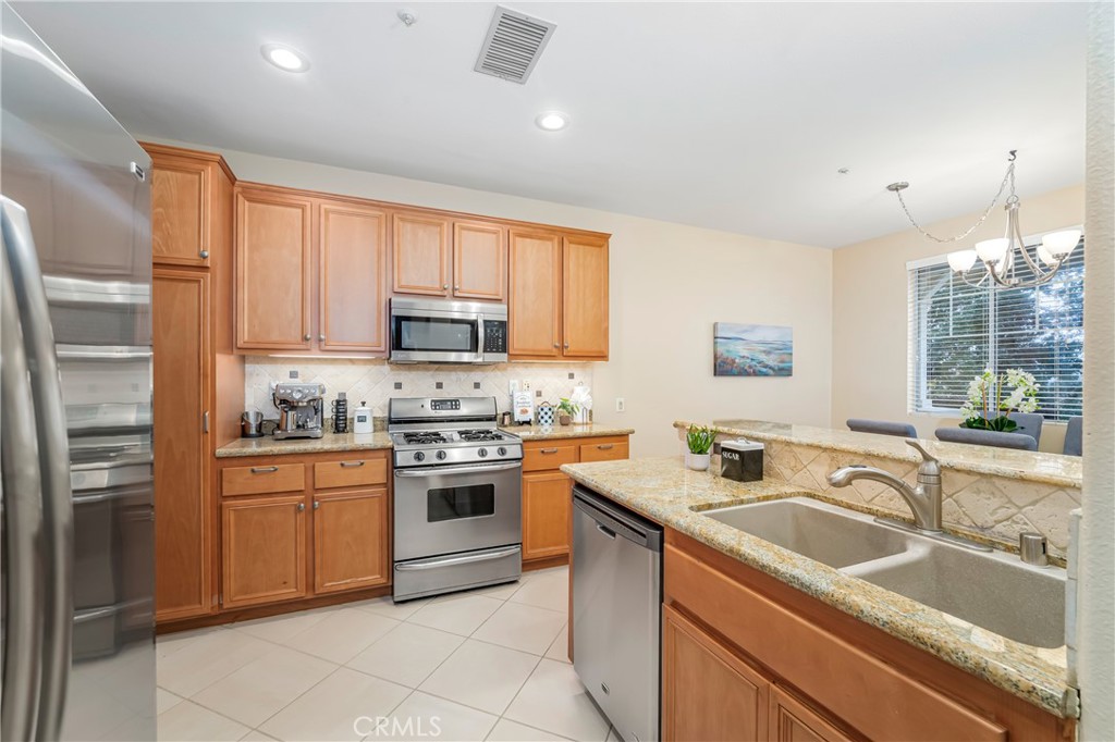 97 Chadron Circle Ladera Ranch, CA 92694 - Photo 13 of 56 Large open concept kitchen with breakfast bar island and direct access to garage and pretty view out the window