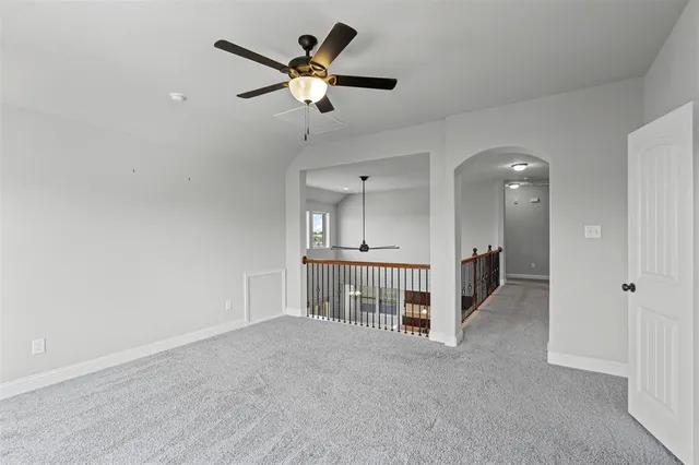 an empty room with a ceiling fan and a bathroom