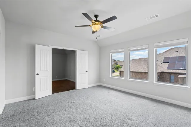 a view of an empty room with window and cabinet