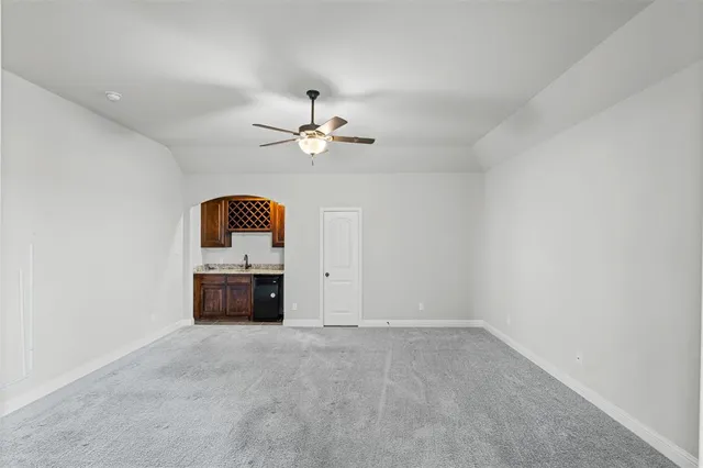 an empty room with a window and a chandelier