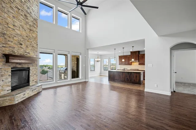 a living room with stainless steel appliances kitchen island a fireplace and wooden floor