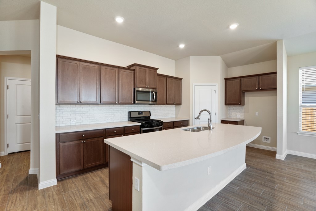 8202 Dampton Lane Austin, TX 78744 - Photo 6 of 25 a kitchen with a sink and a refrigerator