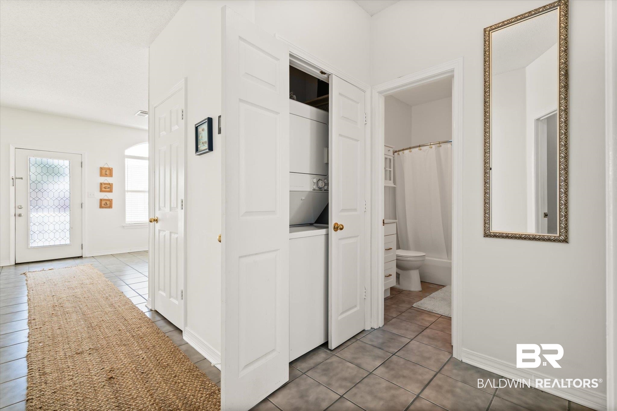 3575 Bayou Road, Unit A 10 Orange Beach, AL 36561 - Photo 15 of 31 Hall with stacked washer and clothes dryer and light tile patterned flooring