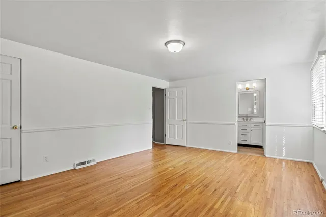 a view of empty room with wooden floor