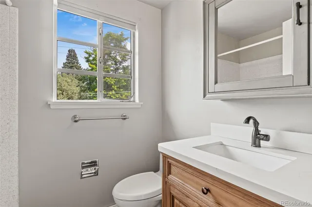 a bathroom with a sink a toilet and a window