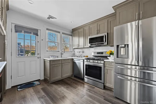 a kitchen with granite countertop a refrigerator stove and sink