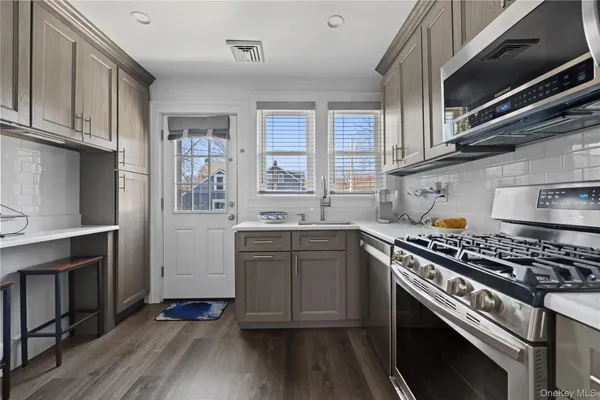 a kitchen with cabinets wooden floor and stainless steel appliances