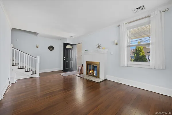 a view of an empty room with a window and fireplace
