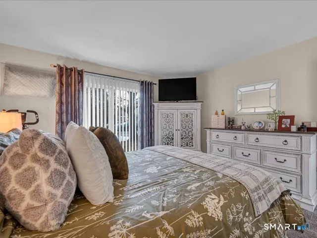 a bedroom with a large bed and a flat screen tv