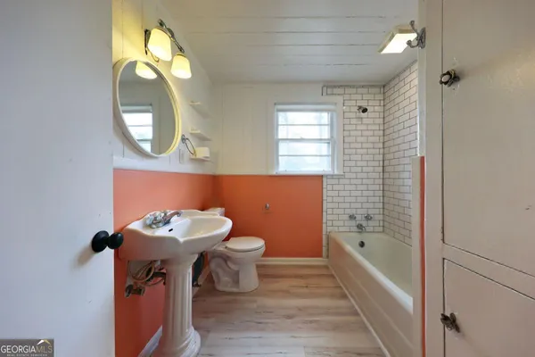 a bathroom with a sink mirror bathtub and toilet