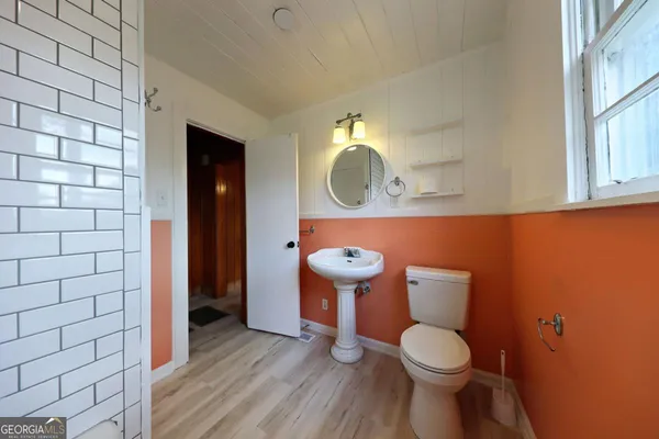 a bathroom with a toilet and a mirror