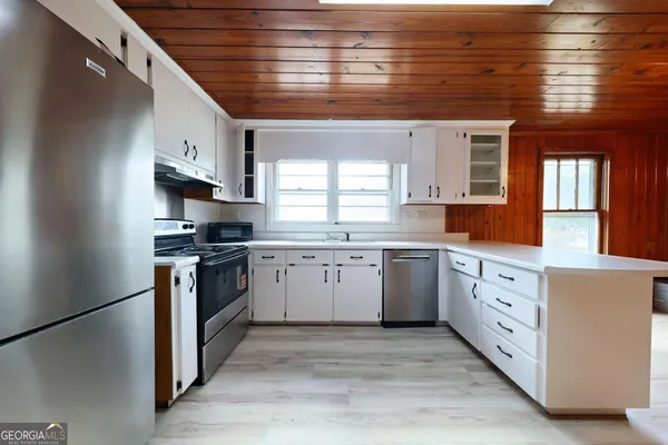 a kitchen with granite countertop white cabinets and white appliances