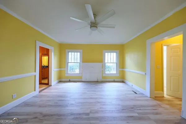 a view of an empty room with a window and wooden floor