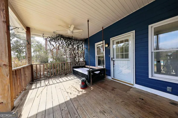a view of a balcony with chairs and wooden floor