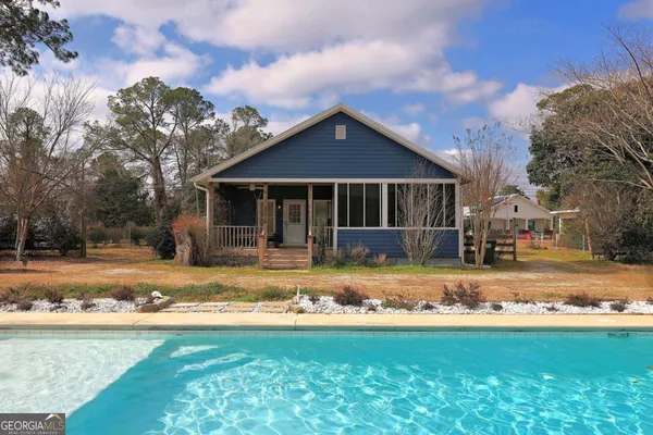 a view of a house with pool and sitting area