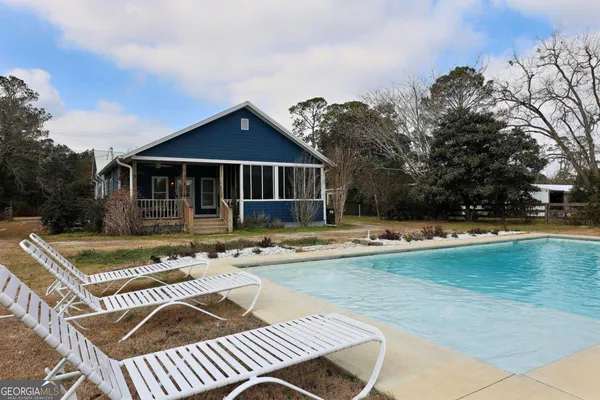 swimming pool with outdoor seating and yard