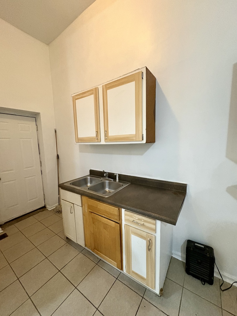 3113 West Roosevelt Road Chicago, IL 60612 - Photo 4 of 11 a kitchen with granite countertop white cabinets and white appliances
