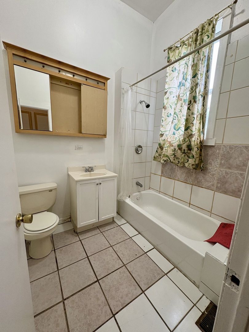 3113 West Roosevelt Road Chicago, IL 60612 - Photo 5 of 11 a bathroom with a sink a toilet and shower