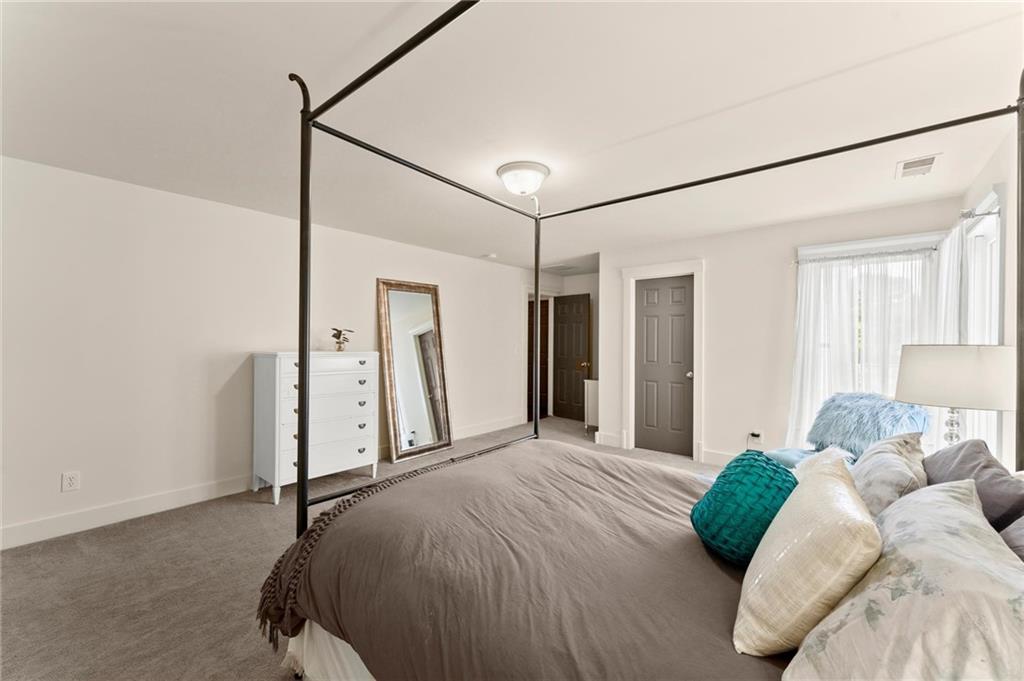 487 Carmichael Circle Canton, GA 30115 - Photo 41 of 65 a bedroom with a bed and a walk in closet