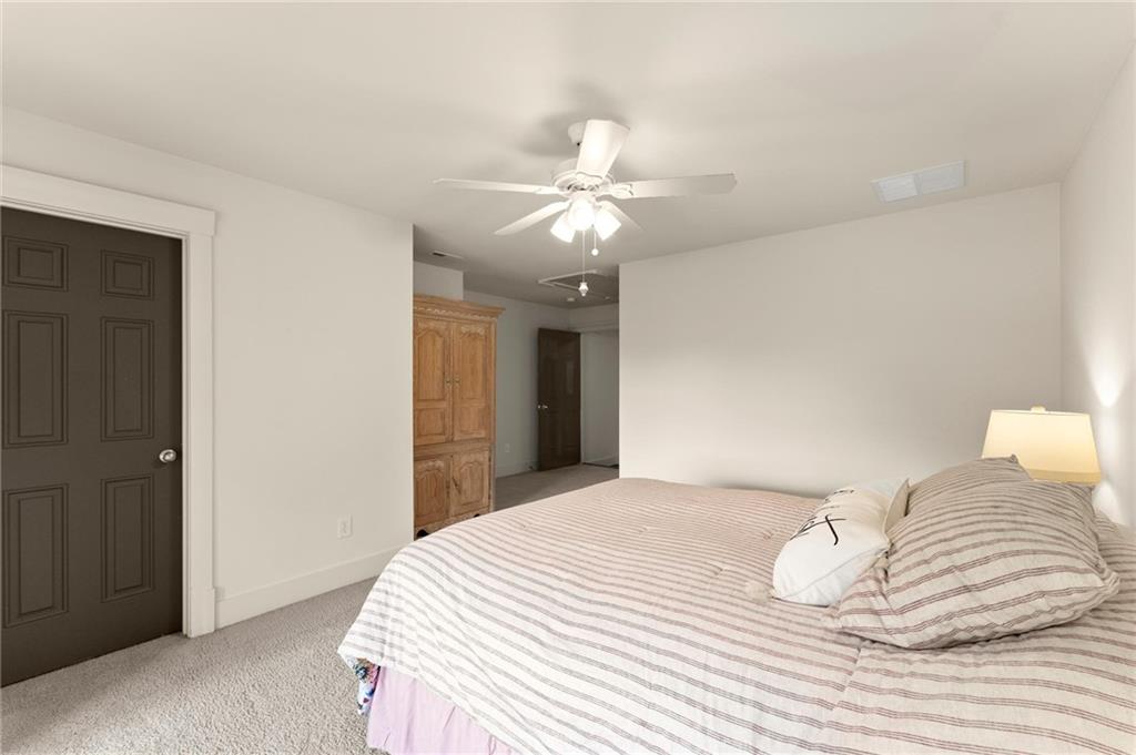 487 Carmichael Circle Canton, GA 30115 - Photo 44 of 65 a bedroom with a bed and a chandelier