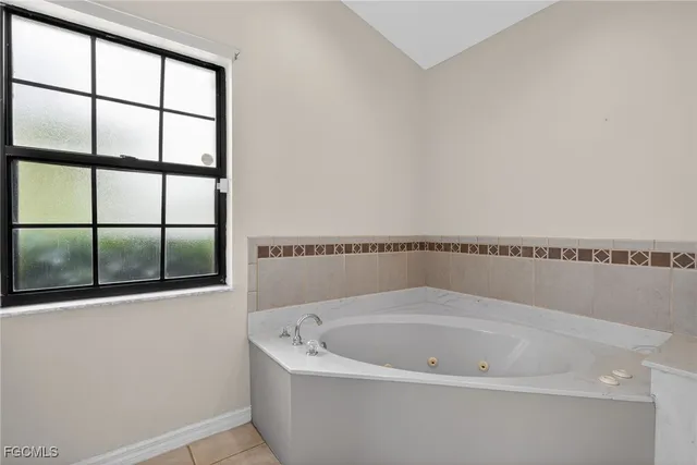 an empty room with windows and ceiling fan