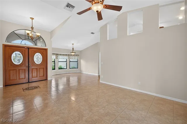 a view of an entryway with a table & chandelier fan