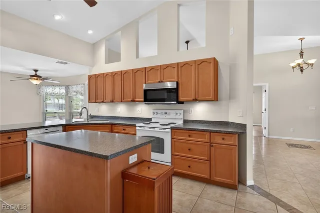 a kitchen with granite countertop a sink stove and microwave