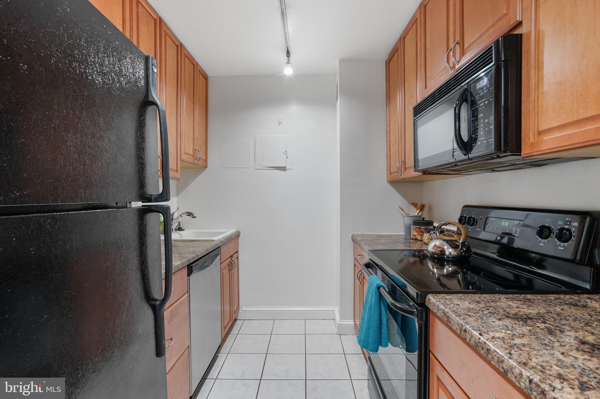 1435 4th Street Southwest, Unit B107 Washington, DC 20024 - Photo 7 of 42 a kitchen with stainless steel appliances granite countertop a stove a refrigerator and a microwave