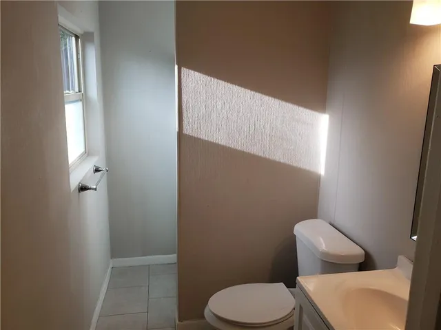 a white toilet sitting next to a bathroom sink and vanity