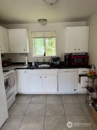 a kitchen with granite countertop a sink and cabinets