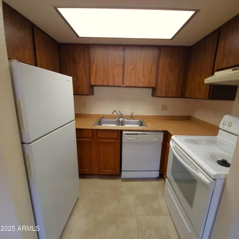 a kitchen with a refrigerator sink stove and cabinets