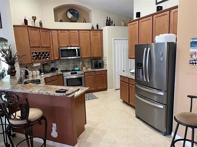 a kitchen with stainless steel appliances a refrigerator a stove a sink and a microwave