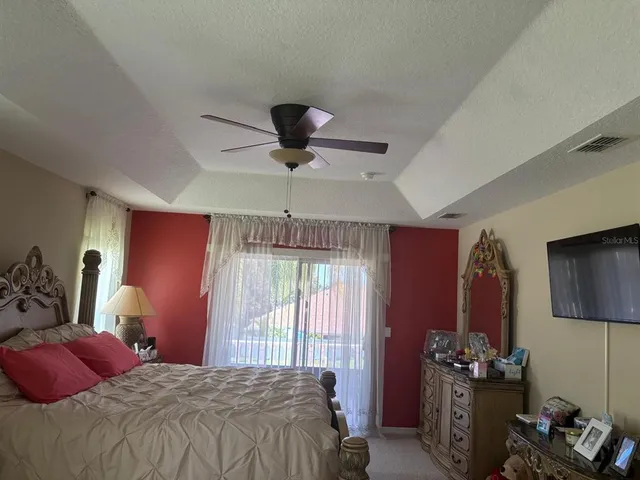 a bedroom with a bed flat screen tv and a large window