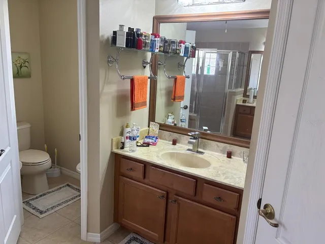 a bathroom with a granite countertop sink a toilet and a mirror