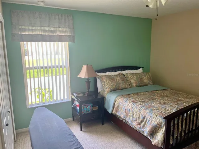 a bedroom with a bed chair and window