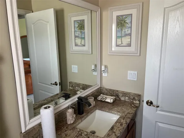 a bathroom with a granite countertop sink and a mirror