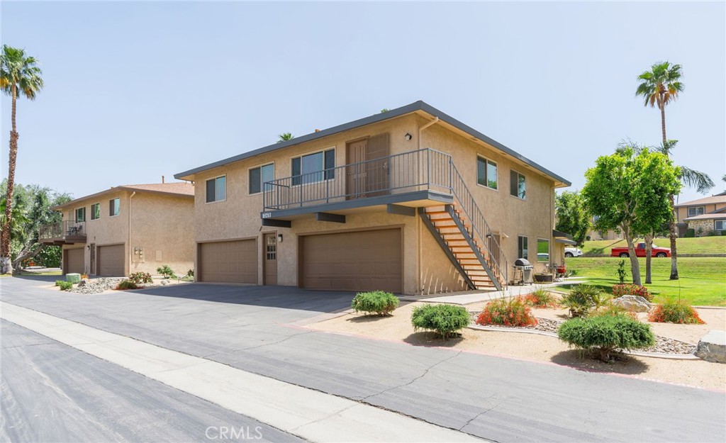 72670 Thrush Road, Unit 4 Palm Desert, CA 92260 - Photo 1 of 1 a front view of a house with a yard and potted plants