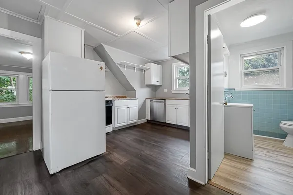 a view of a kitchen with wooden floor and electronic appliances